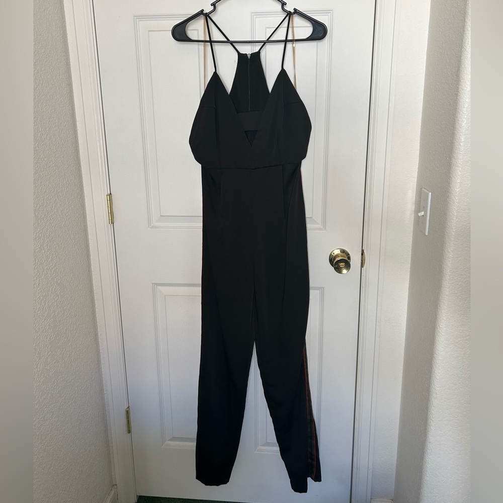 Black jumpsuit with red, navy blue, green details on side. Size M Do + Be.